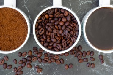 Üst düzey yakın çekim kahve demlenmiş, öğütülmüş ve kavrulmuş kahve fincanları bir arada. Kafeler ve restoranlar için arka plan ve doku olarak kullanılabilir..