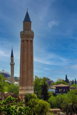 Camilerin minareleri mavi gökyüzüne kadar uzanıyor. Şehir manzarası camiler, yeşil ağaçlar ya da açık mavi gökyüzü birlikte. 