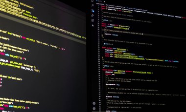 Çift ekran kullanan yazılım geliştirici php ile WordPress kodluyor.