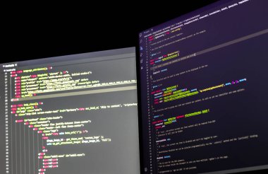 Çift ekran kullanan yazılım geliştirici php ile WordPress kodluyor.