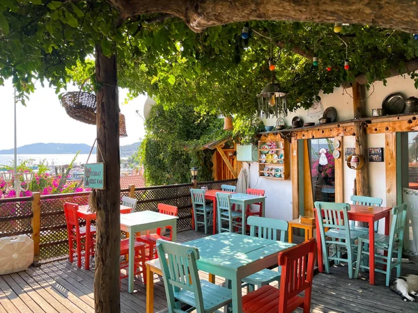 Renkli ahşap masası ve sandalyesi olan küçük bir kafe.