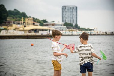 İki kardeş kardeş, deniz kıyısına doğru alçak gelgitte sahili keşfediyorlar. Arkadaşlık mutlu çocukluk konsepti.