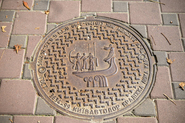 KYIV, UKRAINE - SEPTEMBER 11th, 2021: Sewer hatch with the image of the monument to the legendary founders of the city. The inskription says: Theft of the hatch is punishable by law .