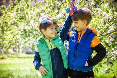 Başarılı yumurta avından sonra iki kardeş arkadaş ellerinde paskalya yumurtalarıyla ayakta ve gülümsüyorlar. Geleneksel Paskalya avı.