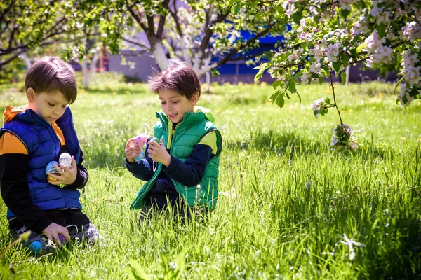 Barn Påskäggsjakt Blommande Vårträdgård Barn Söker Efter Färgglada Ägg Blomsteräng — Stockfoto