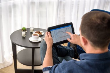 Adam pahalı bir otel odasında bir fincan kahve içerken dijital para ticareti yapıyor..