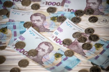 Arkaplan olarak 1000 dolarlık para. Grivna yığınının üzerinde para yatıyor. para kavramı.