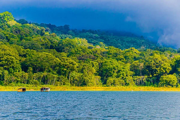 Endonezya 'daki Bali gölünde dağlarla ve kayıkhanelerle manzara