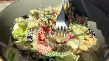 Domatesli Sezar salatası ve parmesan peyniri çatalla kavrulmuş.