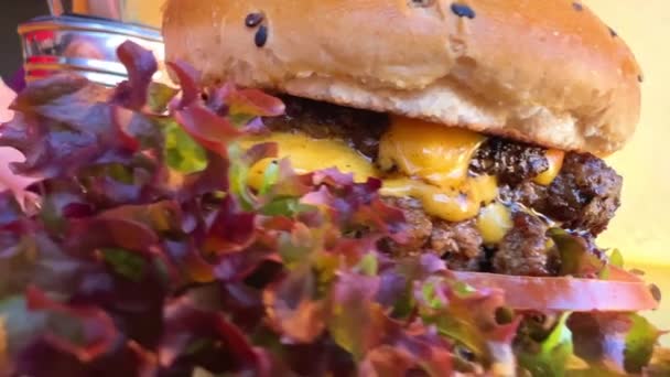 Hambúrguer suculento filmagem hambúrguer com folhas de alface close-up com molho delicioso — Vídeo de Stock