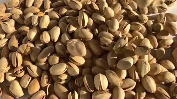 Muchos pistachos caen lentamente en una pila — Vídeo de stock