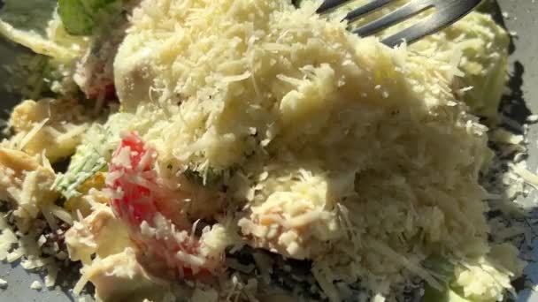 Caesar-Salat mit Tomaten und Parmesan wird mit einer Gabel angekurbelt — Stockvideo