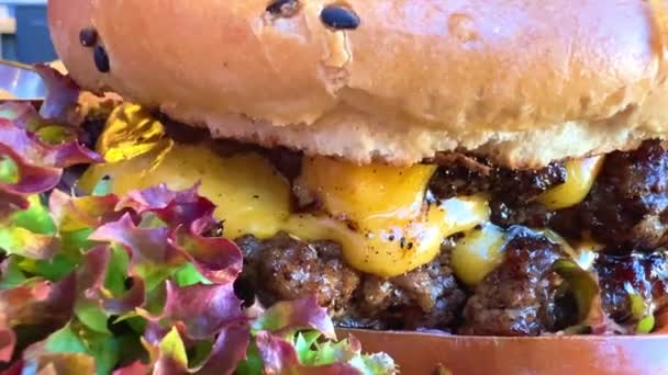 Šťavnatý burger záběry burger s listů salátu close-up s lahodnou omáčkou — Stock video