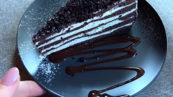 巧克力蛋糕、斯帕达克斯蜂蜜蛋糕和白霜放在盘子里，我用手转着盘子 — 图库视频影像
