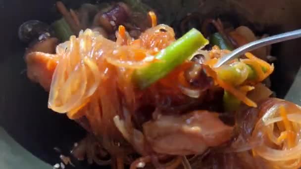 Funchoose chaud avec des légumes de fruits de mer et de la viande dans une assiette noire close-up — Video