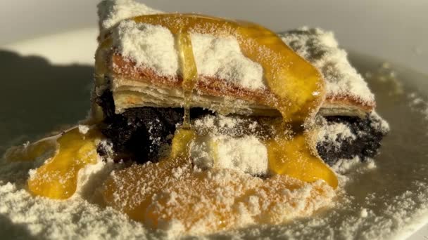 Пирог с маком и сушеным кокосовым молоком засыпан натуральным медом, который стекает на вкусный десерт. — стоковое видео