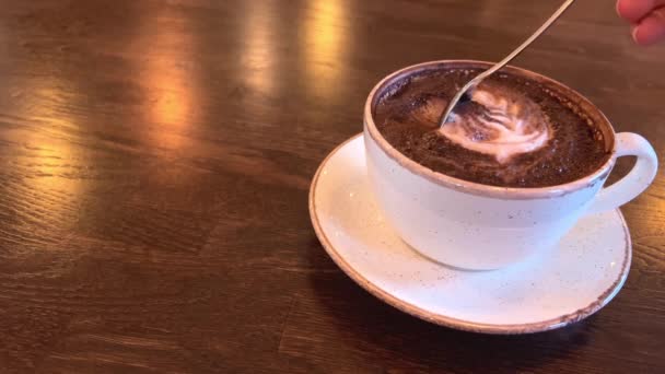 Heißer Kakao in einer weißen Tasse auf einem dunklen Holztisch — Stockvideo