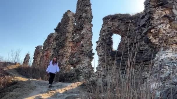 Geen oorlog Oekraïense jonge meisje in een geborduurde blouse op de ruïnes van een oud kasteel verdrietig en kijkt naar alles om zich heen — Stockvideo