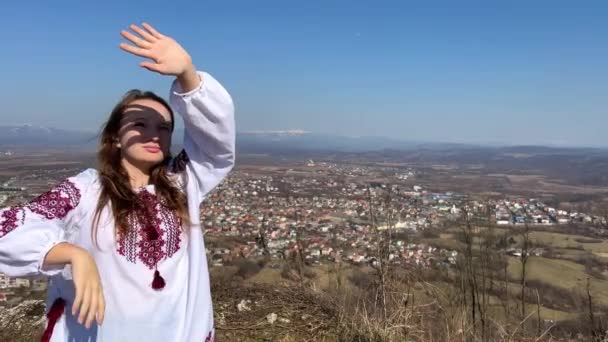 Ninguna joven ucraniana de guerra en una blusa bordada en las ruinas de un viejo castillo tristemente y mira todo a su alrededor — Vídeos de Stock