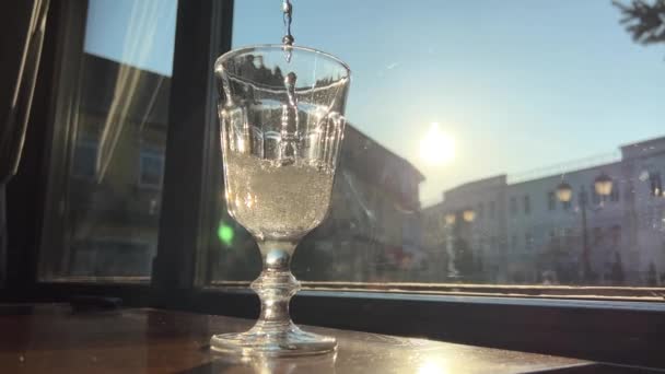 Água carbonatada no vidro contra o fundo da janela e o sol no vidro muitas bolhas de ar se levantam — Vídeo de Stock