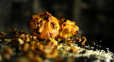 Kekler, tahıl ve cevizlerin yanında fındıkla dağılmış koyu cam bir masanın üzerinde yatıyor.