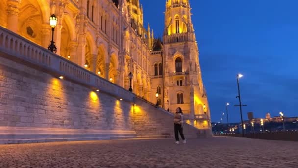 Hongaars parlementsgebouw in Boedapest 's nachts fotografie van felgele verlichte muren en donkerblauwe lucht bij de Donau 03.04.22 Boedapest, Hongarije — Stockvideo