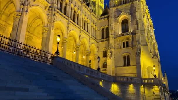 Hongaars parlementsgebouw in Boedapest 's nachts fotografie van felgele verlichte muren en donkerblauwe lucht bij de Donau 03.04.22 Boedapest, Hongarije — Stockvideo