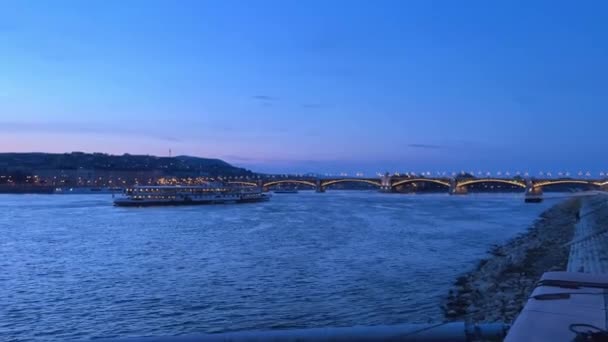 Donau rivier met een schip in de avond vliegt veel kraaien en duiven in de verte brug in de avond zeer mooi alles in blauw 03.04.22 Donau Hongarije — Stockvideo