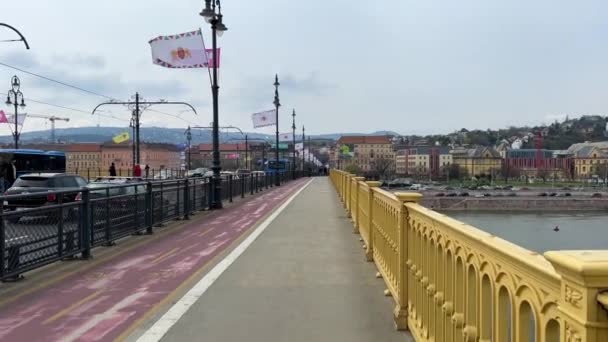 Macaristan Parlamentosu 'nun Tuna Nehri yakınlarındaki Budapeşte köprüsü ve sarı renkli dünyanın en uzun tramvayı, 03.04.22' lik bir dairede çekilmiştir. — Stok video