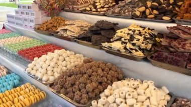 Tezgahtaki farklı tatlılar, gökkuşağının tüm renkleri, jöleli heykelcikten makarna ve çikolataya aktığı kadar serilmiştir..