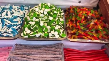 Tezgahtaki farklı tatlılar, gökkuşağının tüm renkleri, jöleli heykelcikten makarna ve çikolataya aktığı kadar serilmiştir..