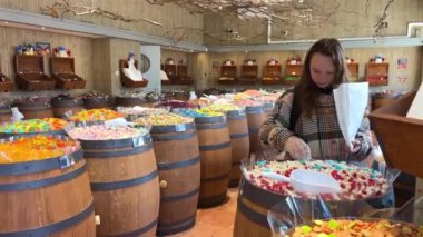 Tezgahın üzerinde farklı tatlılar olan bir kız gökkuşağının tüm renklerini serer. Tıpkı jöleli heykelcikten makarna ve çikolataya kadar tükürüğün aktığı gibi..