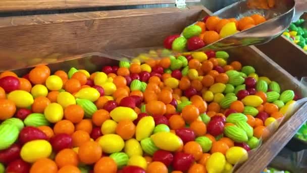 Diferentes dulces en el mostrador están dispuestos todos los colores del arco iris tanto como la saliva fluye desde figuras de gelatina a pasta y chocolate. — Vídeo de stock