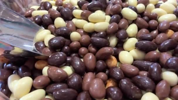 Nueces Diferentes dulces en el mostrador están dispuestos todos los colores del arco iris tanto como la saliva fluye desde figuras de gelatina a pasta y chocolate. — Vídeo de stock