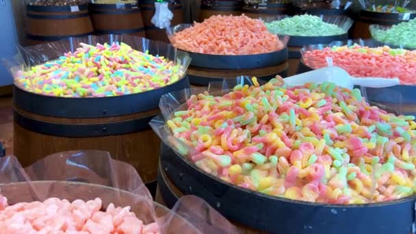 Diferentes dulces en el mostrador están dispuestos todos los colores del arco iris tanto como la saliva fluye desde figuras de gelatina a pasta y chocolate. — Vídeos de Stock