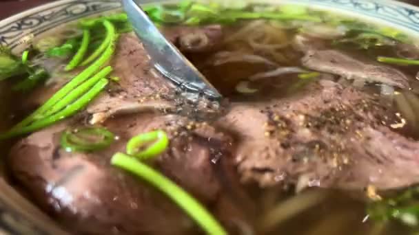 Vietnamese soup Fa Bo on a plate with beef and rice noodles is the unsurpassed taste of it eaten with chopsticks — Stock Video