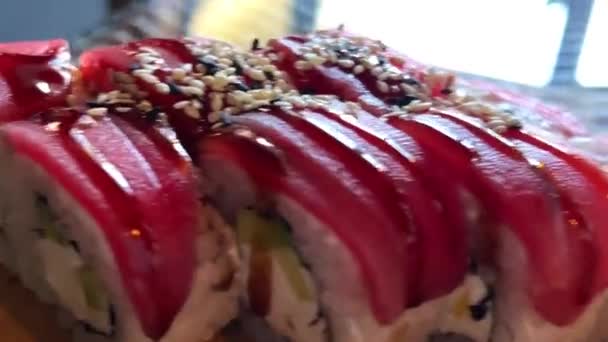 Ställ sushi philadelphia med lossos tonfisk och ål på en träskiva i restaurangen äta med ätpinnar det är mycket välsmakande och trevlig — Stockvideo