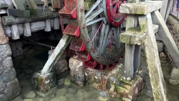 Holzmühle schöpft Wasser mit roter Schöpfkelle — Stockvideo