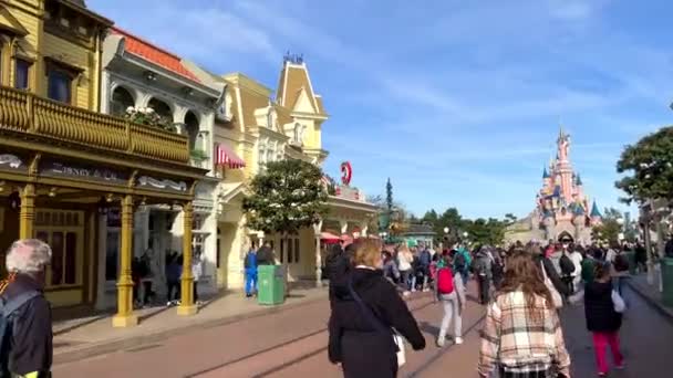 Disneyland street casas coloridas mucha gente brillante vida feliz cielo azul y fabulosos edificios y personajes de dibujos animados 11.04.22 Disneyland Paris Francia — Vídeos de Stock