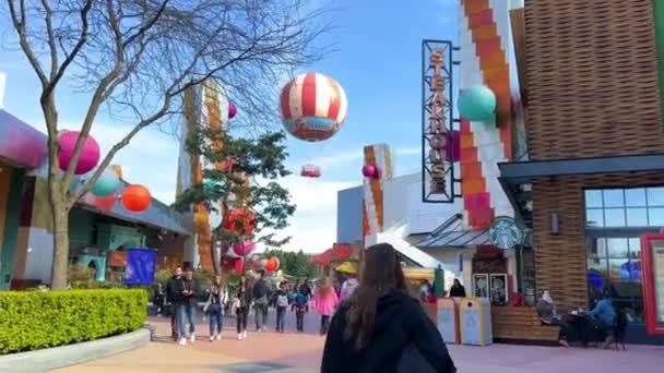 Disneyland Straße bunte Häuser viele Menschen hell glücklich Leben blauer Himmel und fabelhafte Gebäude und Zeichentrickfiguren 11.04.22 Disneyland Paris Frankreich — Stockvideo