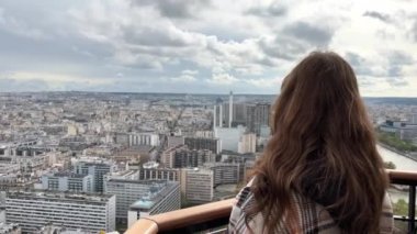 Eyfel kulesindeki bir kız Paris şehrine bakar. Görünür evler Seine Nehri ve şehir merkezi 06.04.22 Paris Fransa.