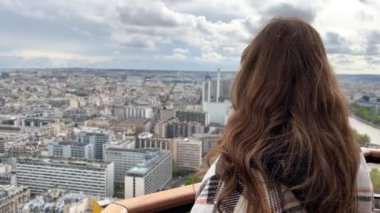 Eyfel kulesindeki bir kız Paris şehrine bakar. Görünür evler Seine Nehri ve şehir merkezi 06.04.22 Paris Fransa.
