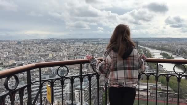 Eyfel kulesindeki bir kız Paris şehrine bakar. Görünür evler Seine Nehri ve şehir merkezi 06.04.22 Paris Fransa. — Stok video