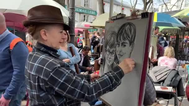 Sulla strada di Parigi, gli artisti dipingono volti di ragazzi e ragazze atmosfera creativa ovunque 11.04.22 Parigi Francia — Video Stock