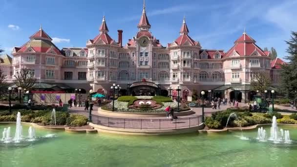 Różowy hotel z zegarem przy wejściu do Disneylandu Paryż Zamek przy wejściu 11.04.22 Disneyland Paryż Francja — Wideo stockowe