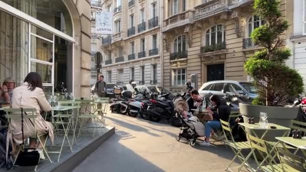 Słoneczne ulice Paryża, kawiarnie, samochody i ludzie w atmosferze spokoju i relaksu 15.04.22 Paryż Francja — Wideo stockowe