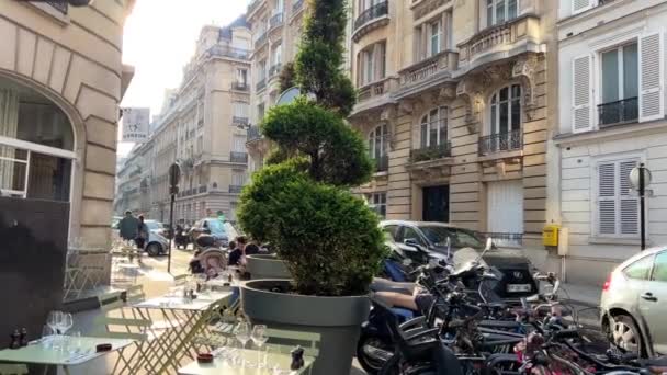 Słoneczne ulice Paryża, kawiarnie, samochody i ludzie w atmosferze spokoju i relaksu 15.04.22 Paryż Francja — Wideo stockowe