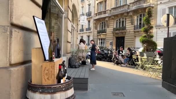 パリの日当たりの良い通り,カフェ,車や静けさとリラクゼーションの雰囲気の中で人々 15.04.22パリフランス — ストック動画
