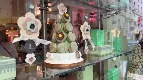 Okno obchodu s těstovinami v Paříži zelené makróny laduree jsou vystaveny v podobě vánočního stromečku 15.04.22 Paříž Francie — Stock video