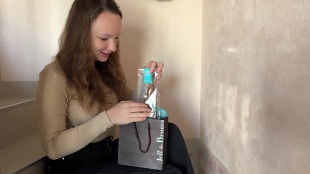 제프 드 브 루주 십 대 소녀가 맛있는 벨기에 초콜릿 한 봉지를 들고 부활절 토끼 초콜릿을 꺼내는 모습 — 비디오